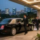 Oswego IL limousine service featuring a professional chauffeur assisting guests at a luxury venue in Chicago.
