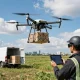 The DJI FlyCart 100 drone delivering a heavy package in a clear field, showcasing its advanced capabilities for efficient logistics.