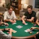 Teman-teman menikmati permainan poker yang intens di rumah, menyoroti SBOBET88 dan permainan yang strategis.