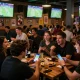 Pengguna SBOBET88 bertaruh di bar olahraga yang ramai dengan penggemar, minuman, dan kegembiraan