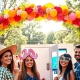 Capture the joy of a photo booth rental at an outdoor event, with guests enjoying fun props.