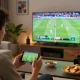 Placing strategic kèo nhà cái bets on a smartphone while watching live football in a modern living room