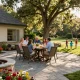 Paver patio near me with a family enjoying an outdoor meal, vibrant flowers, and a fire pit.