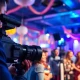 Event videography capturing a vibrant celebration with guests and a dedicated videographer.