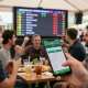 Cheering sports fans engaged in debet betting during a live event, smartphones in hand.