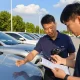 Instant reg check UK at a car lot with a buyer using smartphone to verify vehicle details.